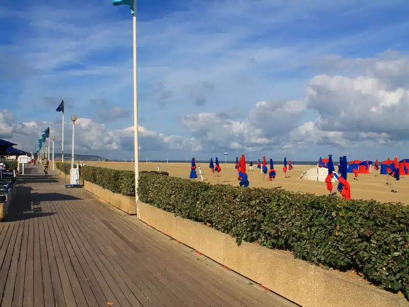 Boarwalk in front of a beach with colourful beach parasols