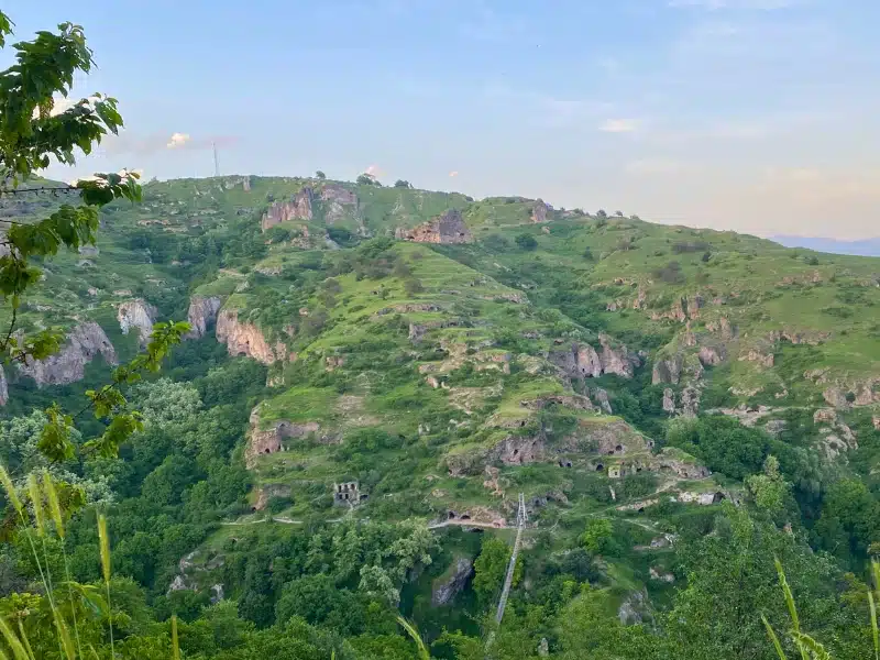 openings to cave dwellings seen on a grassy hillside