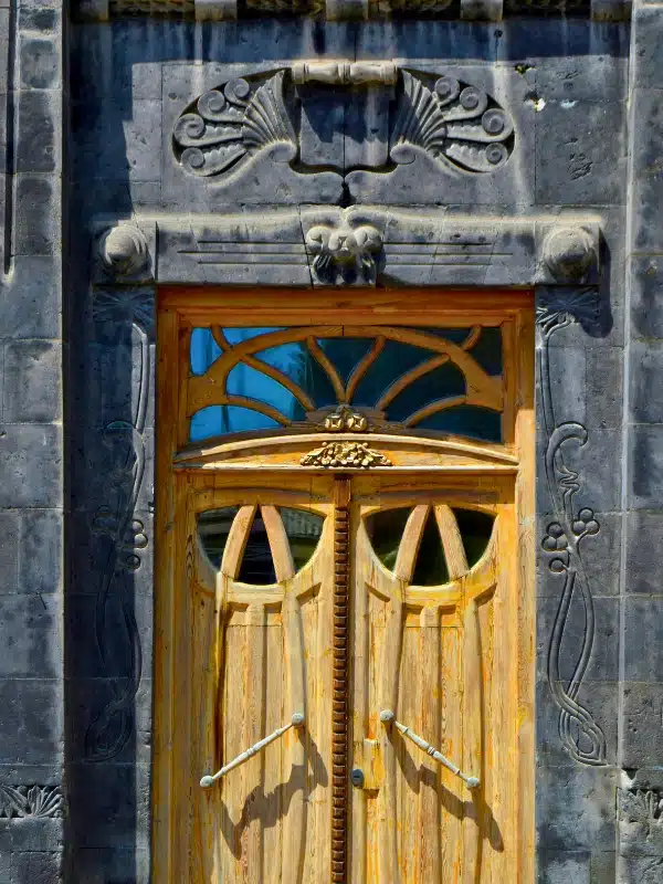 A wooden door surrounded by black stone