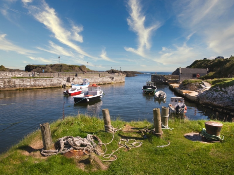 small stone harbor with colourful boats