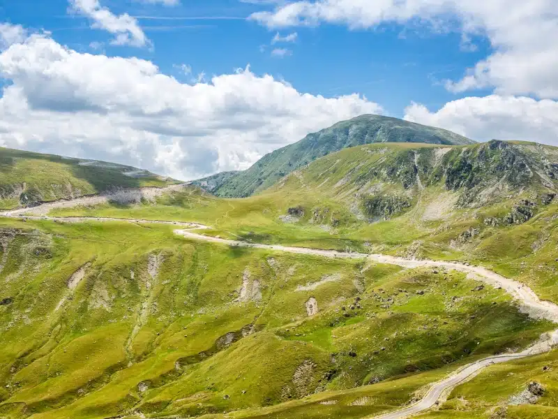 Mountain road through green and rocky landscape