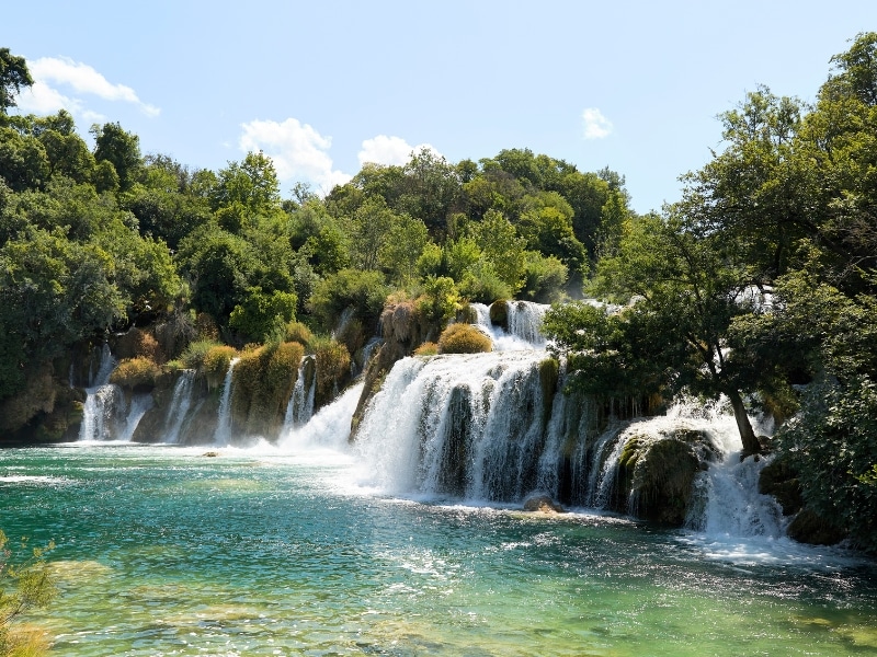 wide waterfall into a shallow lake