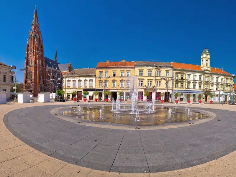 Row of houses in front of a square with pavement fountains