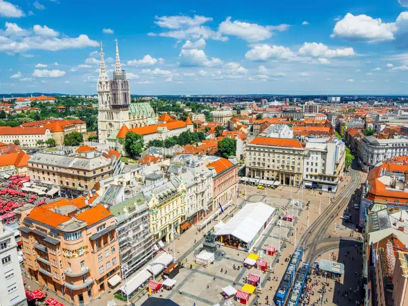 Tall church and red roofed buldings around a central square