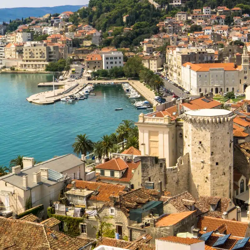 old stone buildings with teraccotta roofs by a small sea port