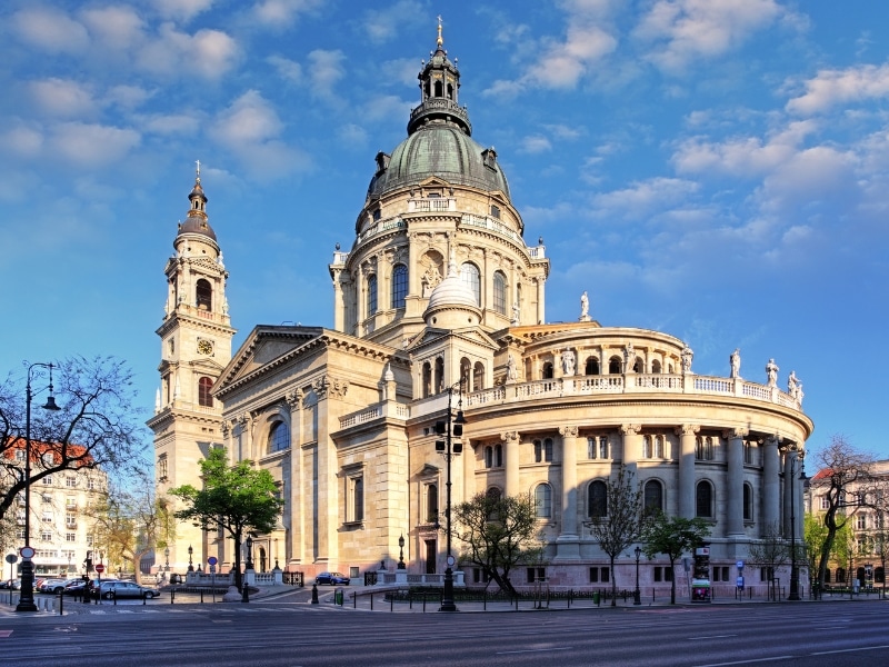 An image of a church with a green copper dome against a blue sky