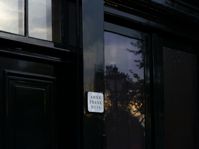 sign on a black painted door which says "Anne Frank Huis"