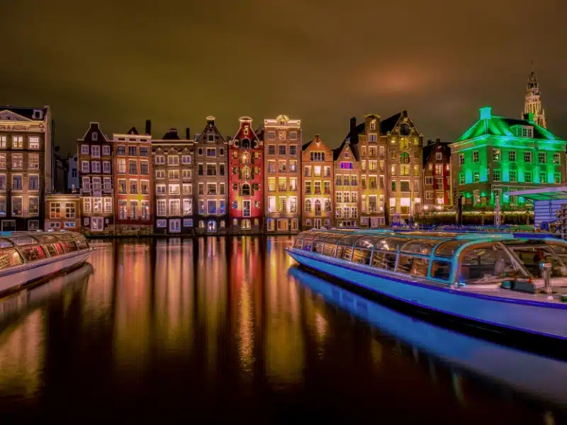 Building shine at night with a canal in front and a boat