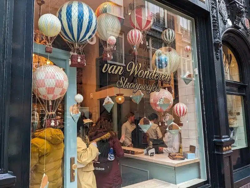 Image of a shopfront showing model hot air ballong and the name Van Wonderan Stroopwafels on the glass in gold lettering