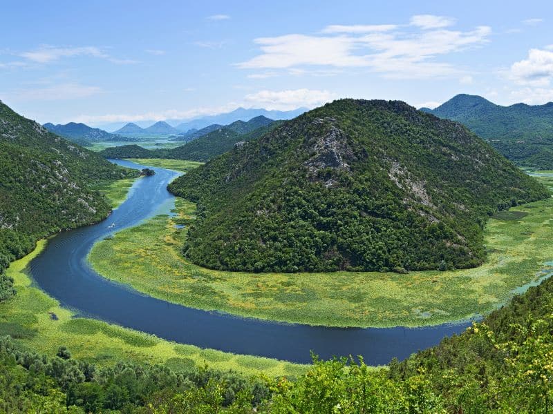 Green hills and a bend in a lake lined with water reeds