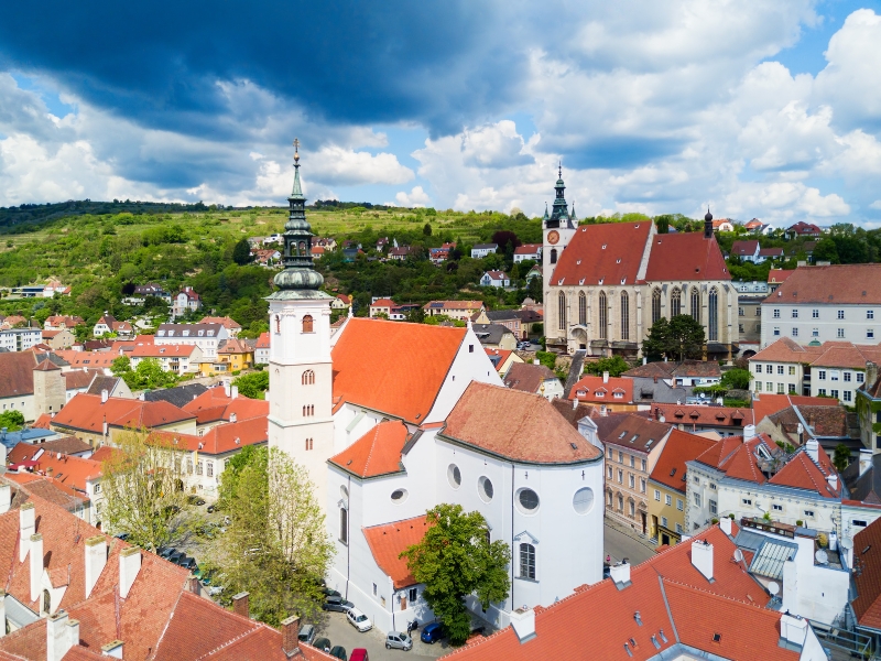 White church with terracotta roof and copper verdis gris spire