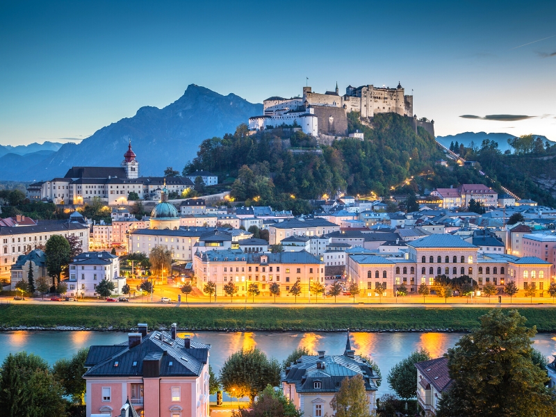 Castle on a hill overlooking an Austrian city at dusk