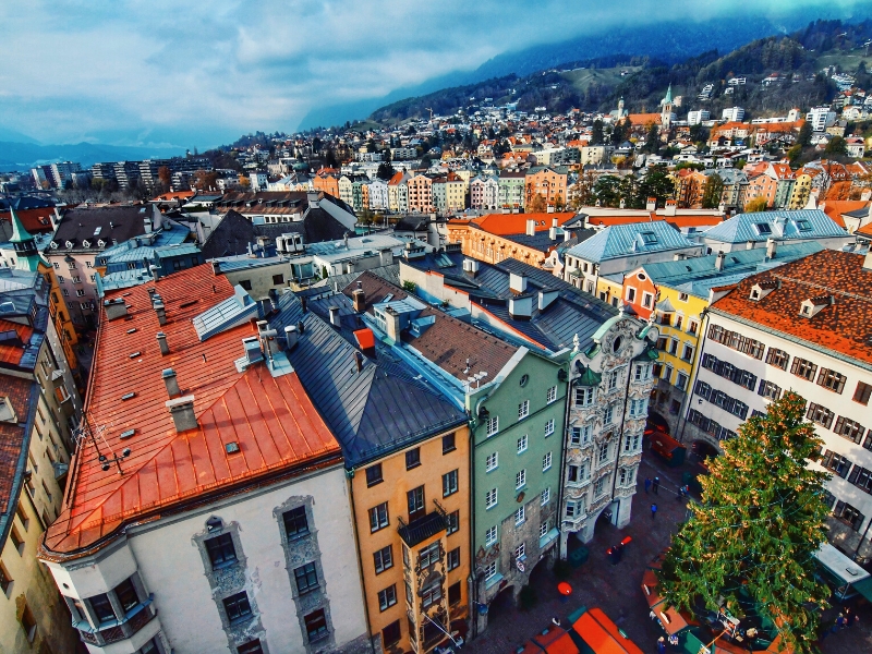 Colorful town houses with ornate decoration and mountains in the background