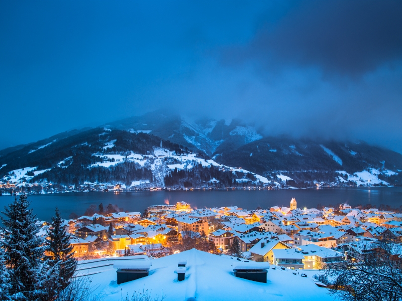 Snow covered town by a lake in the evening
