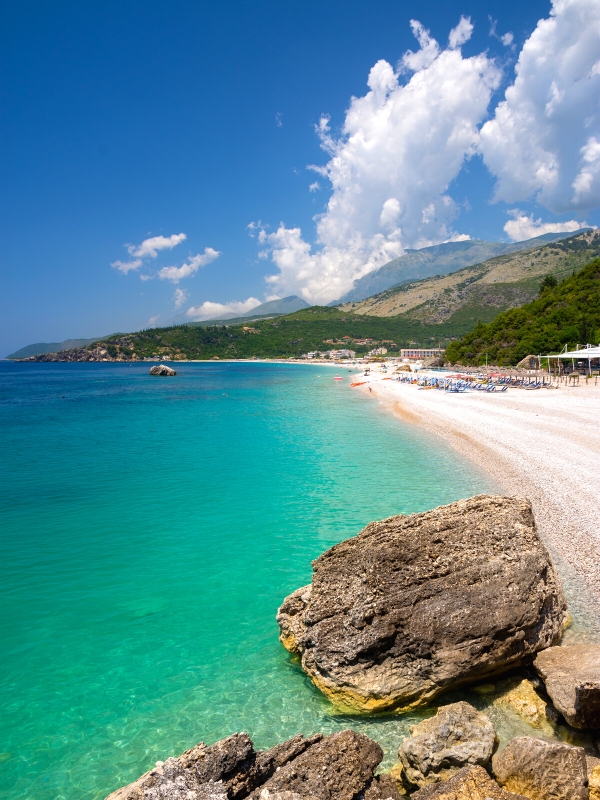 green and blue sea by a shingle beach