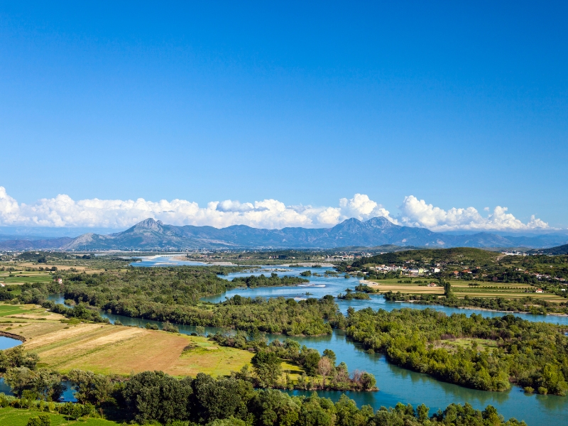 lake and river winding between small islands with mountains in the background