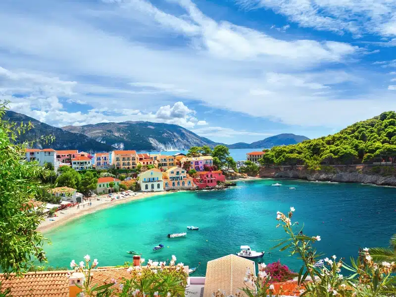 Turquoise bay with a small village of painted houses and sandy beach