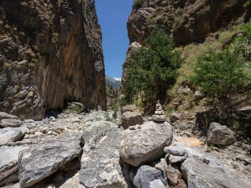 narrow dry river gorge and canyon with large rocks in the forefront