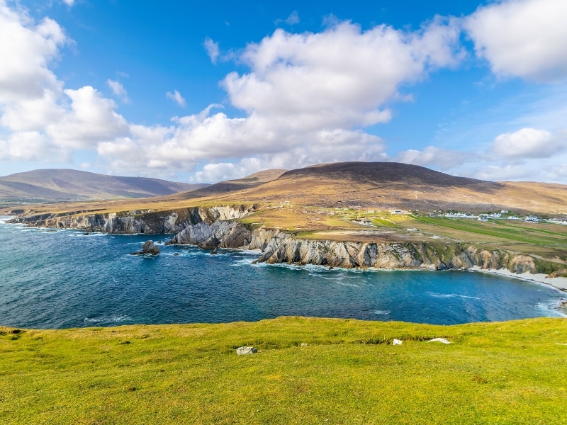 Green fields, blue sea and a small sandy cove