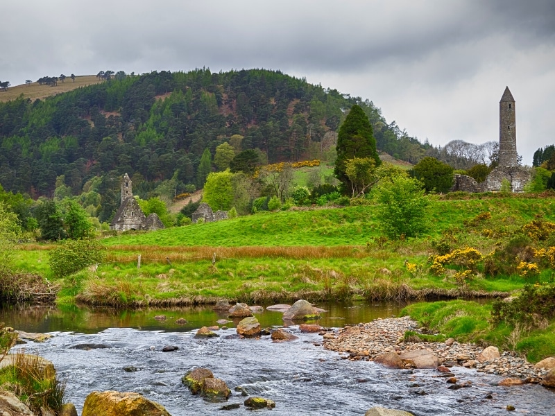 View of a stony riner across a valley with a small stone church and tower