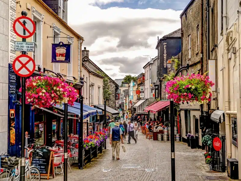 Busy and colourful cobbled shopping street in an Irish town