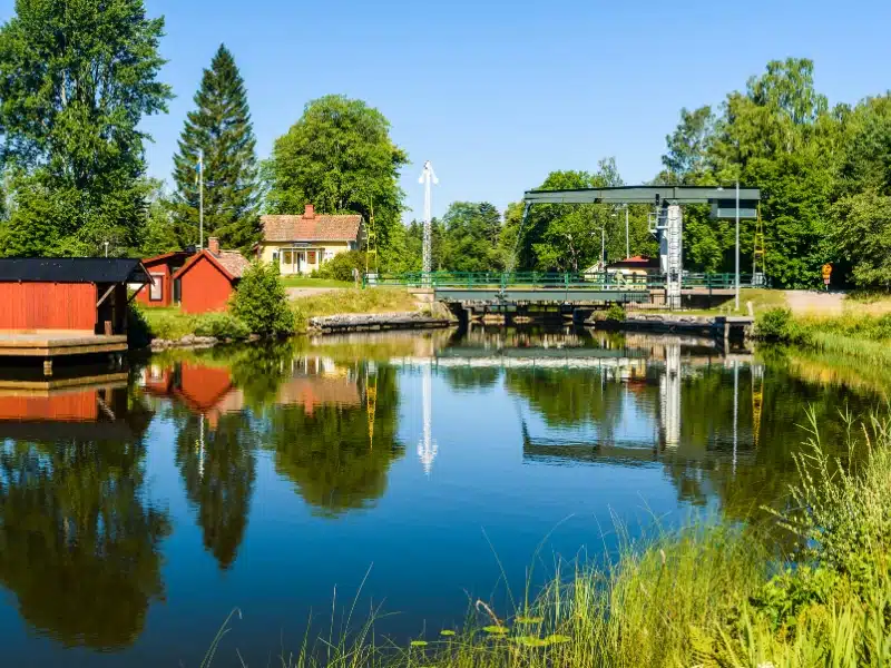 canal with a lock and red houses lined by grass