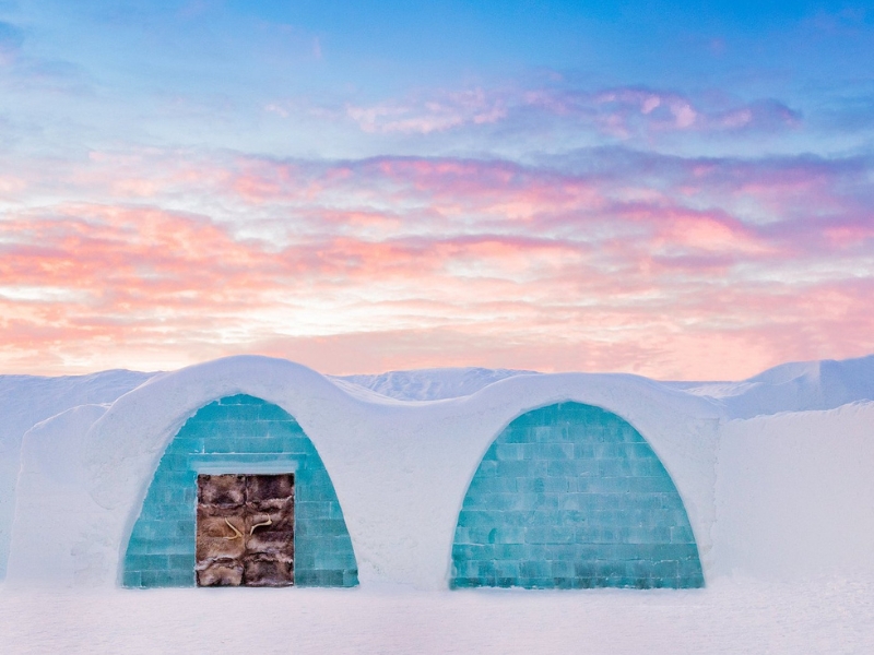 two arched doorways with blocks of gree blue ice covered in snow