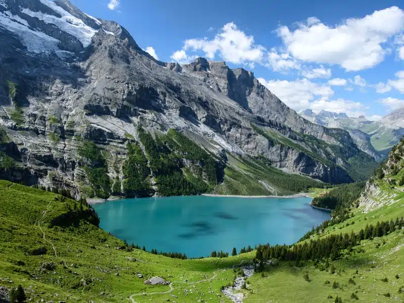 Alpine lake surrounded by meadows and mountains