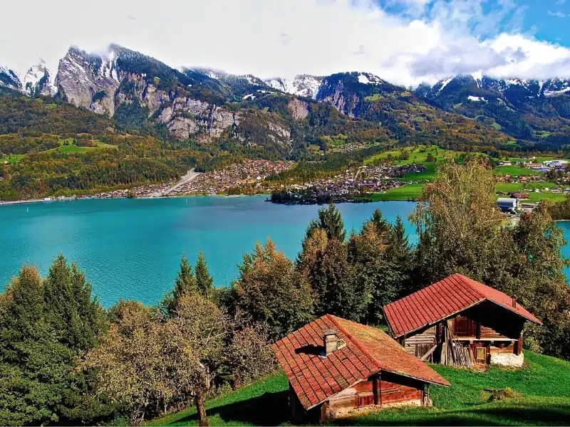 Turquoise lake with red roofed houses and mountains