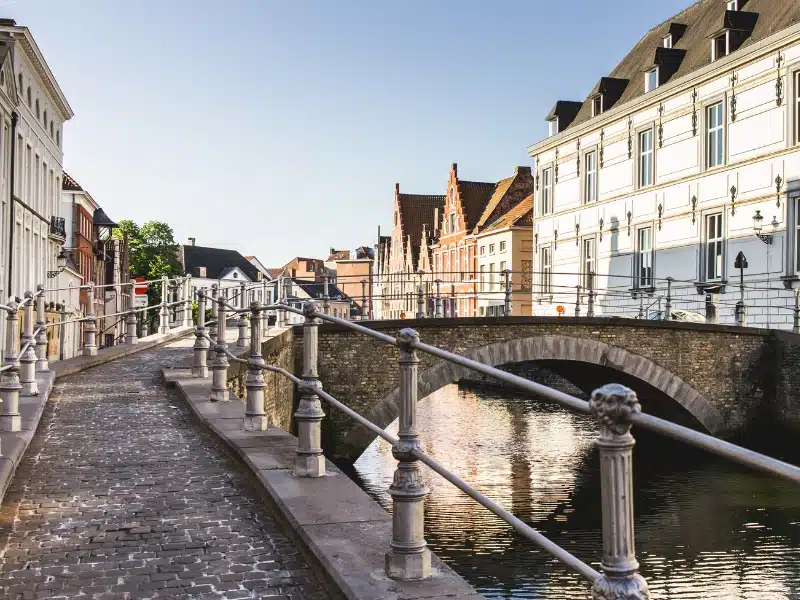 A bridge over a canal lined with white buildings