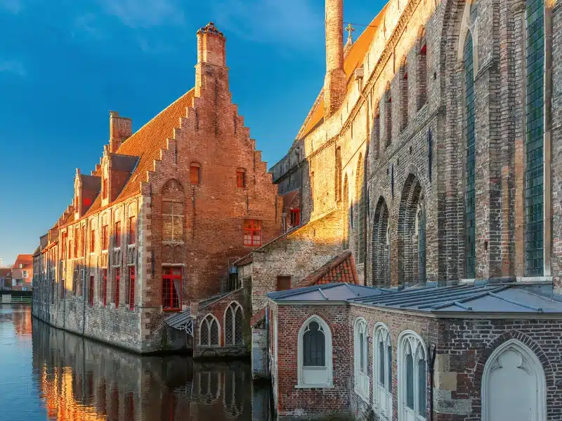 Historic red bricl buildings in a canal in Belgium
