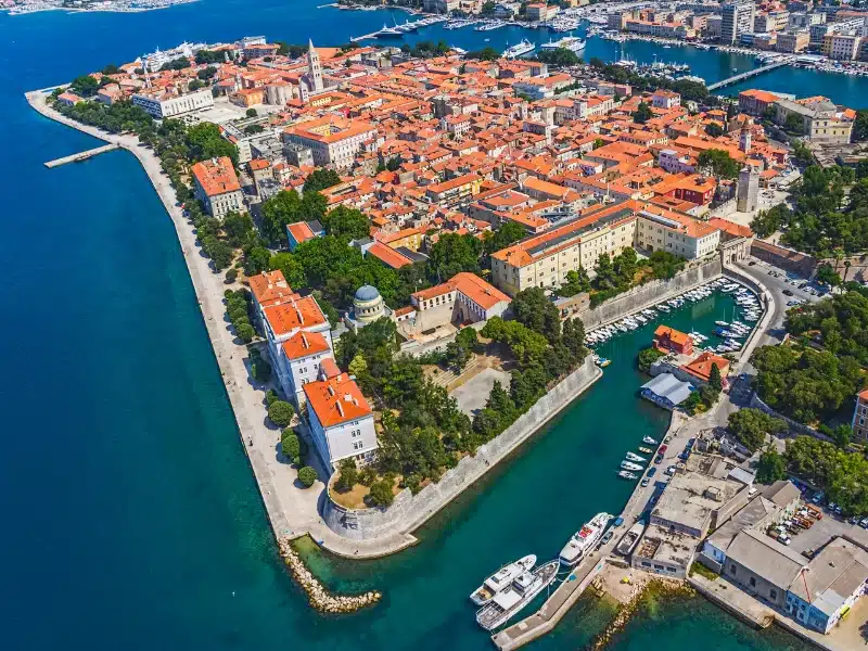 Red roofed city surrounded by turquoise water