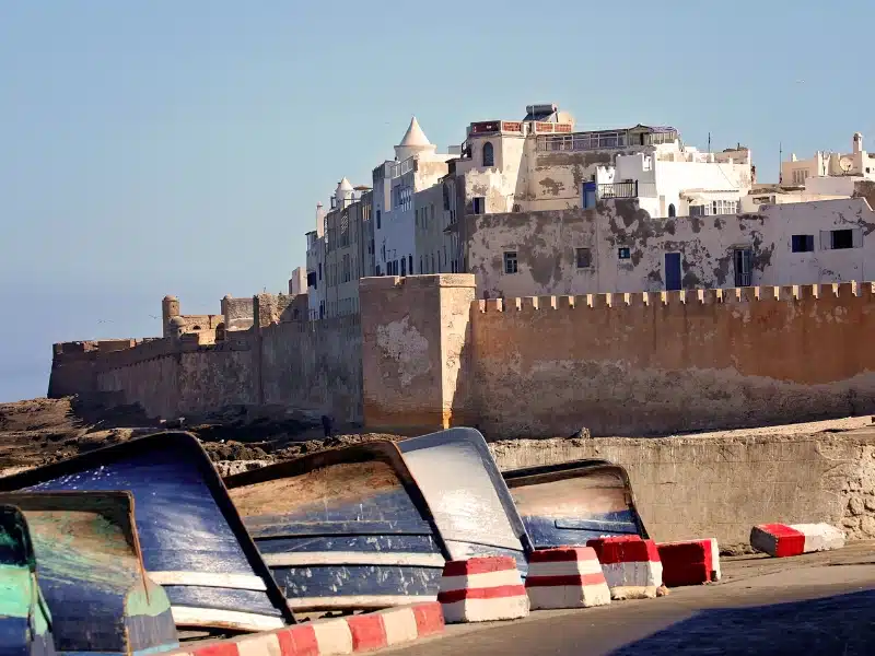 Moroccan coastal town walls backed by sand and boats