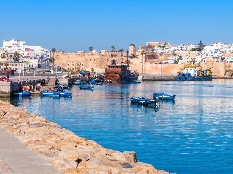 Moroccan walled town by a harbour with blue boats