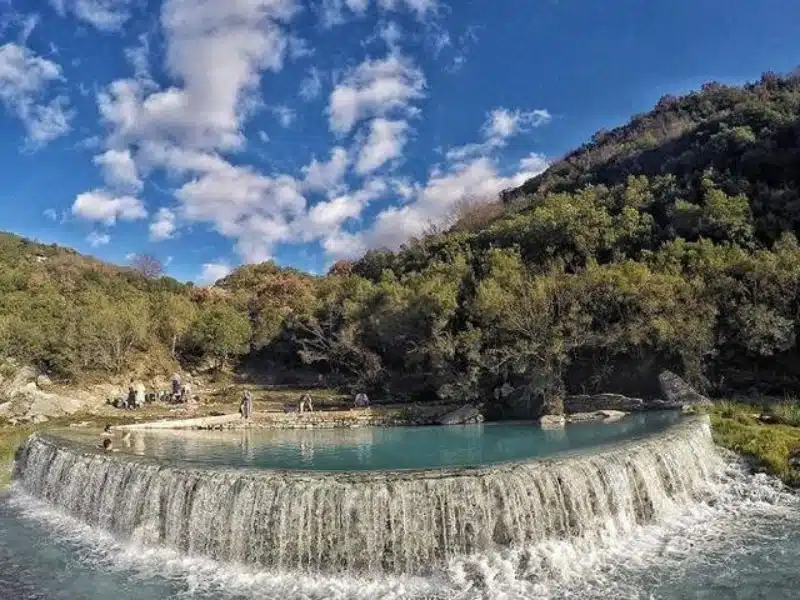 Thermal waters cascading over a limestone pool