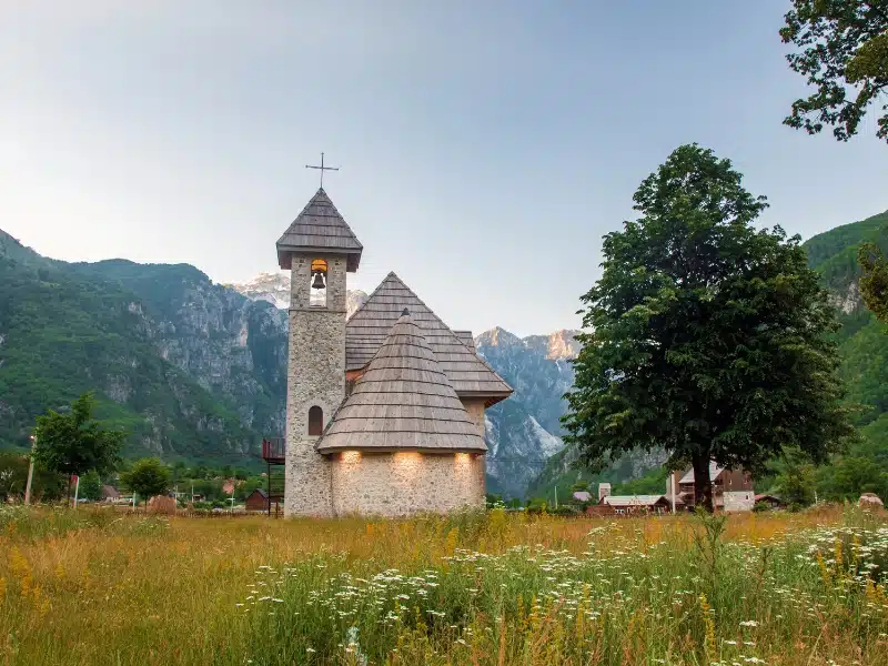 stone church with wood shingle roof at twilight