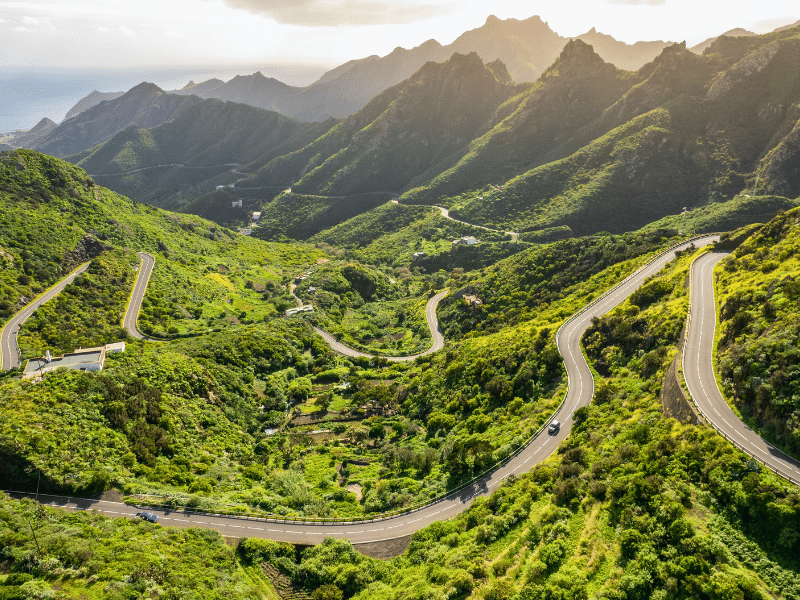 Aerial view of green volcanic landscape with serpentine road in northern part of Tenerife, Canary Islands, Spain.