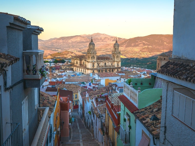 steep steps lined with colorful houses and a large cathedral int he background