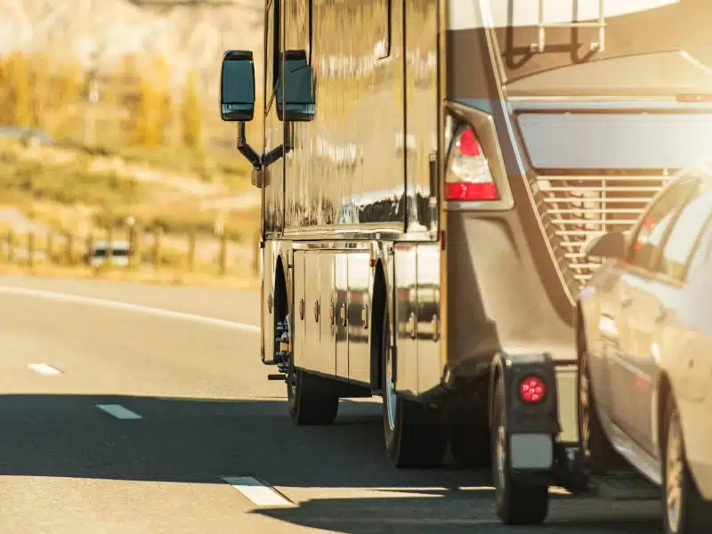 large RV style motorhome towing a car