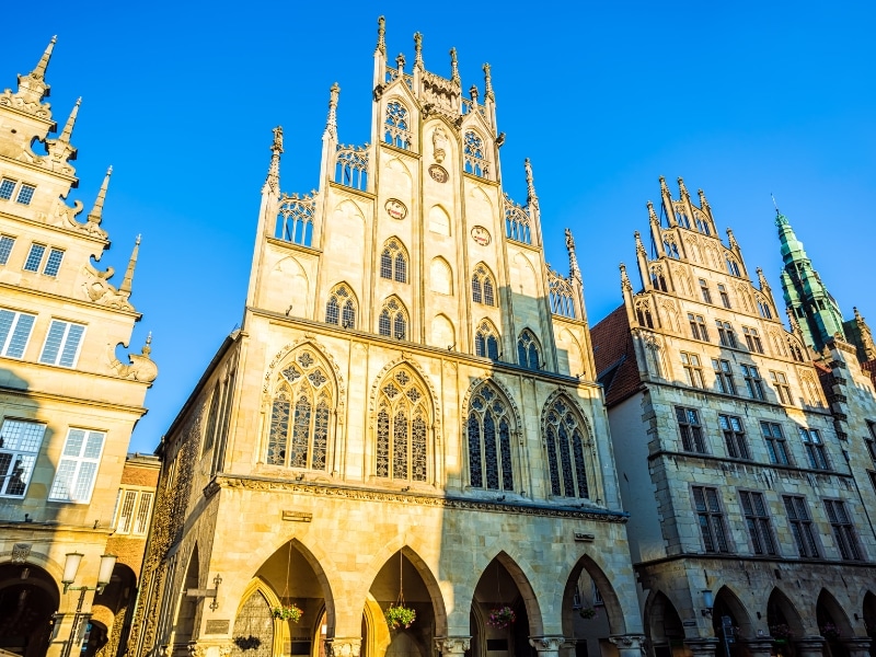 ornate creamy stone buildings with arched porticoes, oval topped windows and detailed gabling