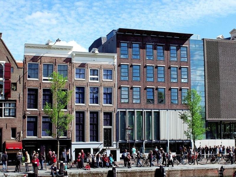 mix of modern and historic red brick houses with groups of people walking and cycling along the path in front