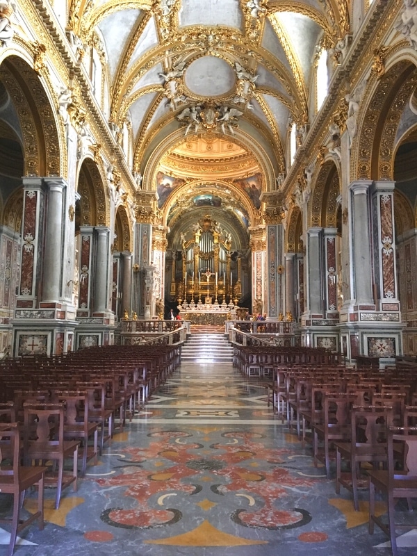 inside an Italian basilica with ornate decor and tiled floors
