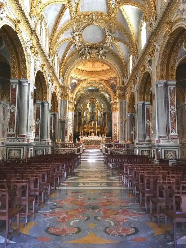inside an Italian basilica with ornate decor and tiled floors