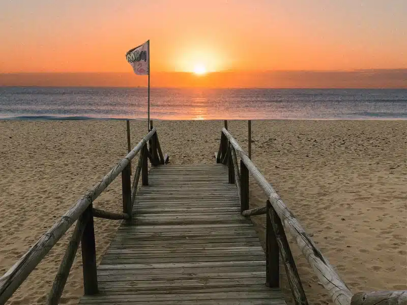 sunset over a beach and wooden boardwalk