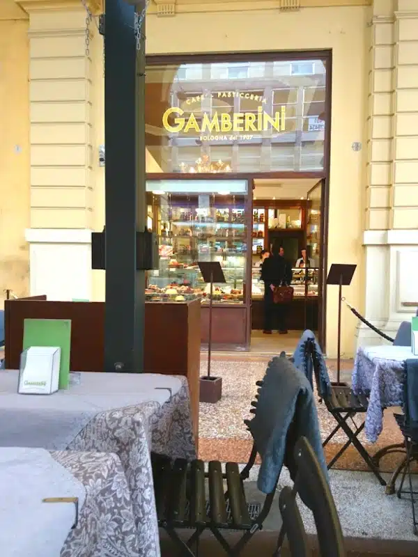 outside of an Italian cafe with chairs and tables on the pavement