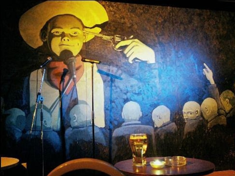 painting on a wall of a boy wearing a cowboy hat and holding a gun
