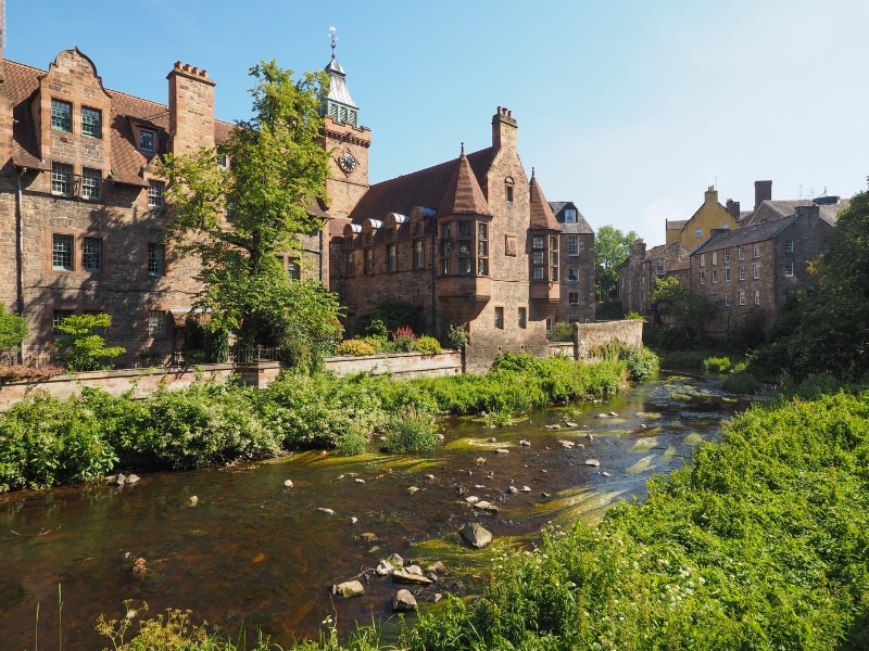 historic red brick buildings next to a river