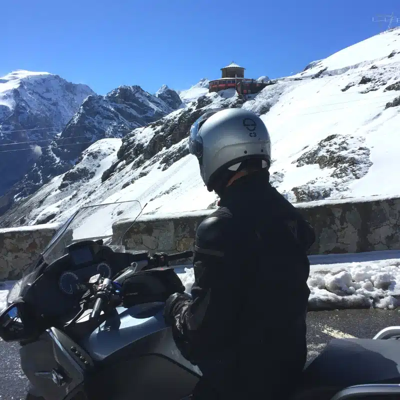 motorbike and rider wearing a silver helmet surrounded by snow
