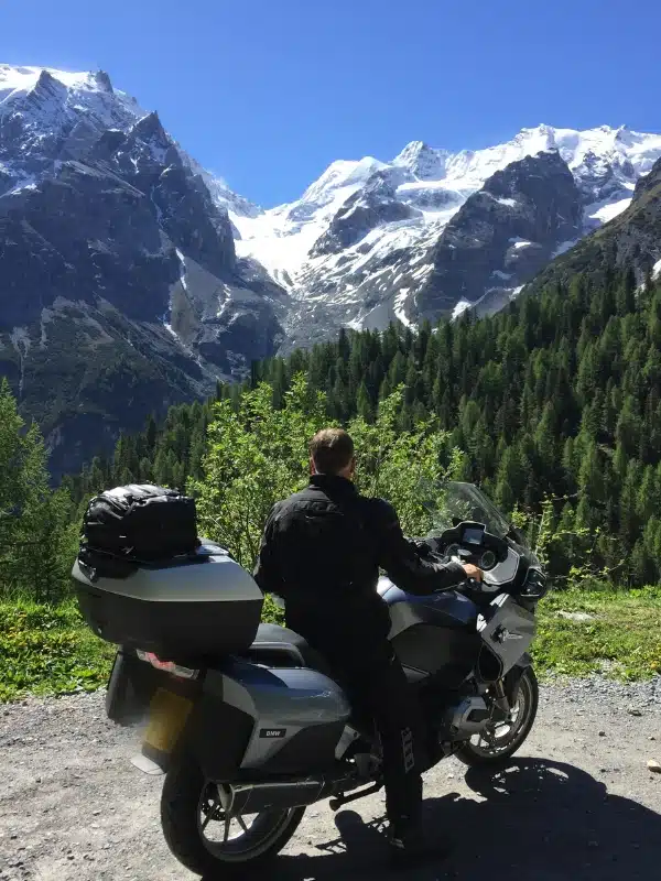 Man on a motorbike admiring a mountain view