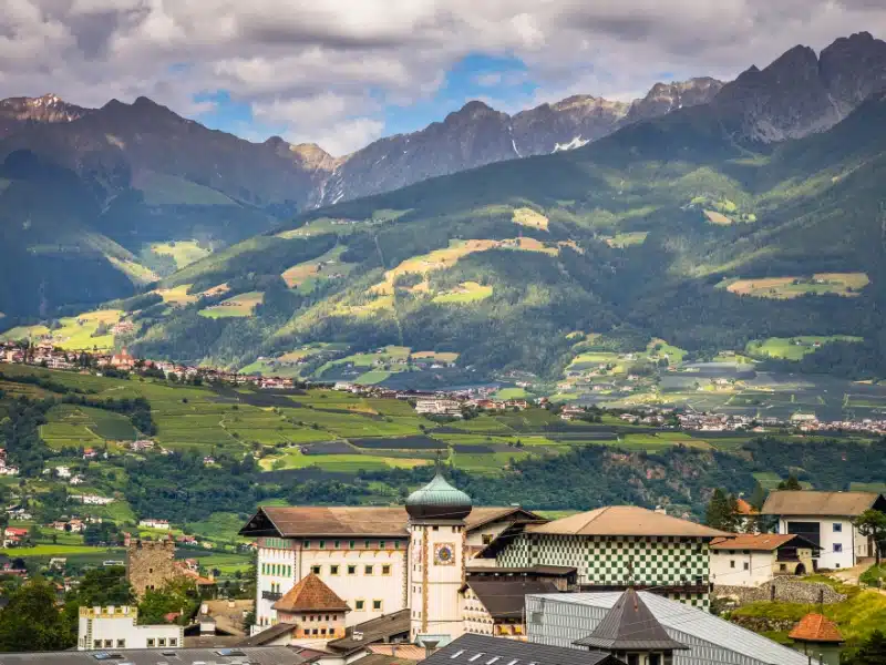 small Alpine town with an onion domed church surrouned by large mountain peaks